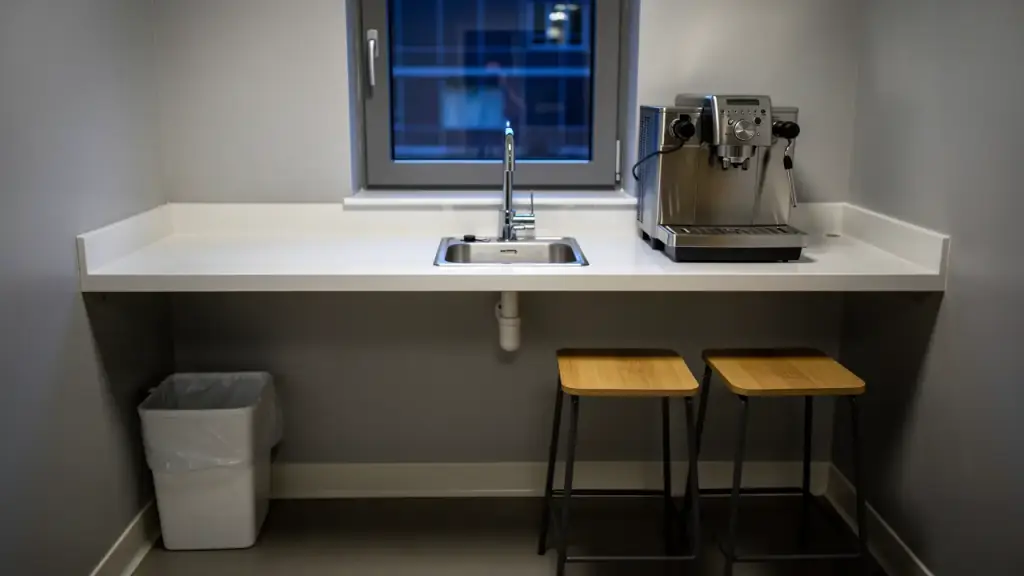 Office breakroom counter wiped clear with a polished sink and coffee machine
